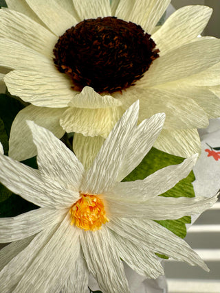 A close-up of the Dirty Martini paper bouquet highlighting the pale yellow sunflower and white daisy poms, showing the finely veined petals and crisp lemon-leaf and silver-dollar eucalyptus accents.
