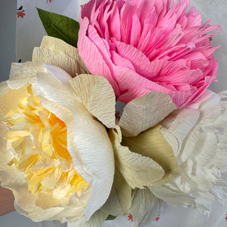 Close-up of pink and white handmade paper peonies accented by sage green paper lambs ear