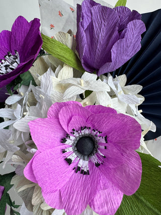 Close-up of purple and white flowers with green leaves on a white background