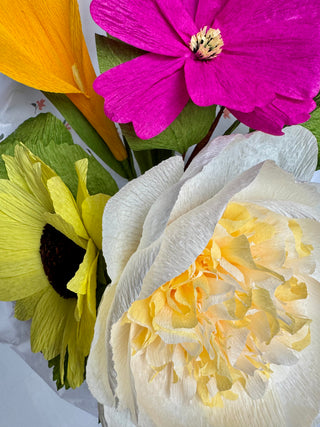 Close-up of flowers in Soul Ties bouquet; magenta cosmo, orange calla lily, ivory peony and yellow sunflower.  The petals of the flowers have texture mimicking the petals of each flower. 